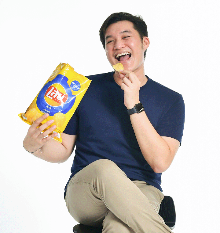 Man holding a Lay's bag eating